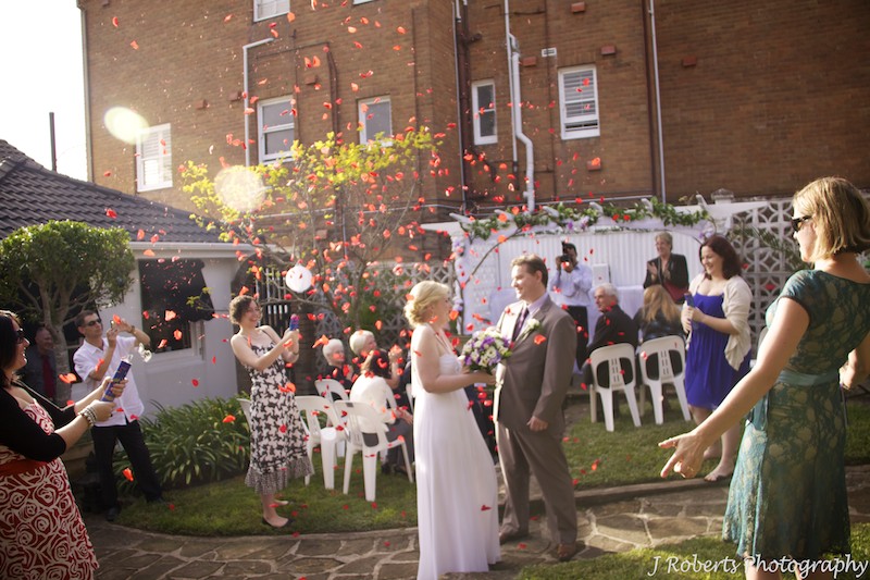 Bride and groom under rose petal cannons - wedding photography sydney